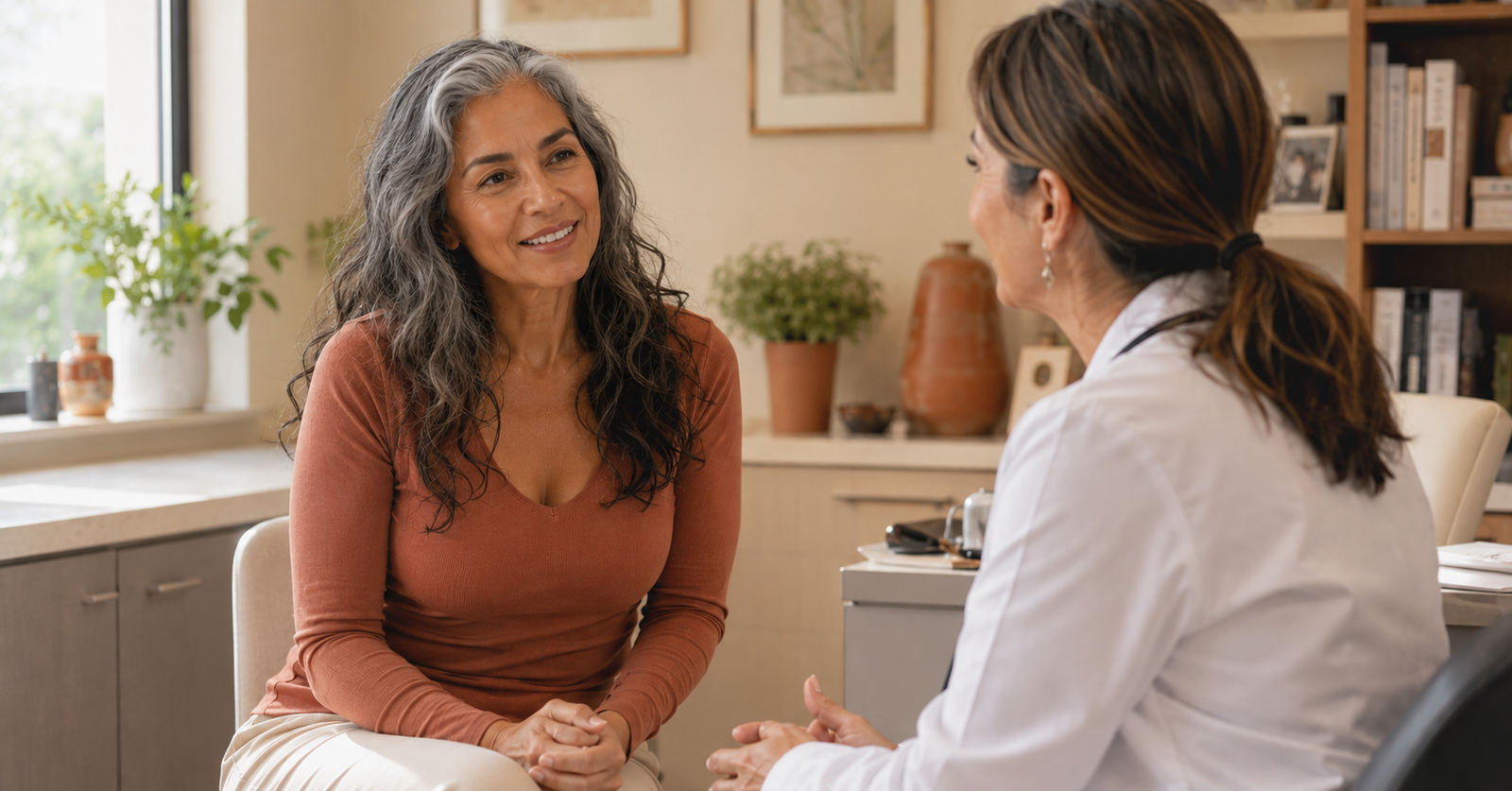 Mujer de 50 años conversando con su médica sobre terapia hormonal en la menopausia